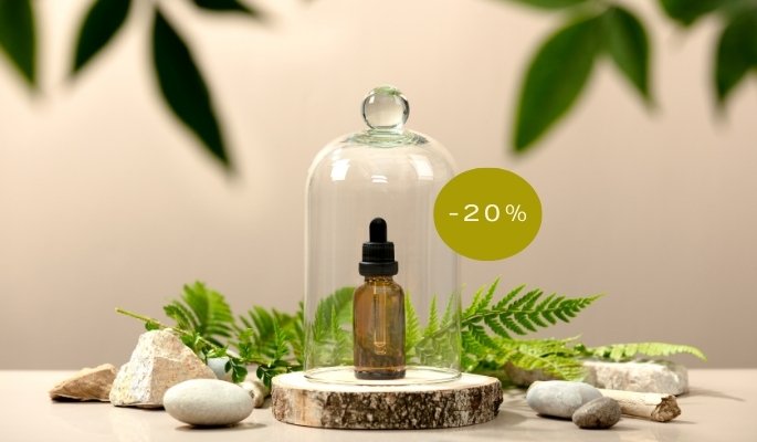 Flacon de soin cosmétique naturel posé sur un présentoir en pierre avec des feuillages, mise en avant des promotions Rooseel